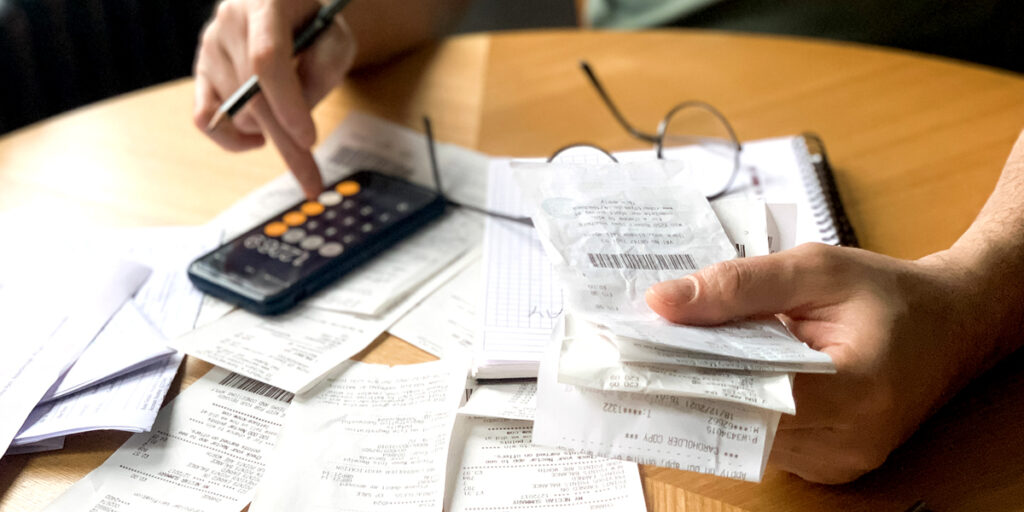 Person hält Quittungen und Belege in der Hand - wie lange müssen Quittungen aufbewahrt werden?